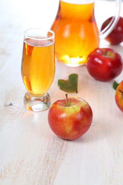 Jugo de manzana y manzanas sobre una mesa de madera —  Fotos de Stock