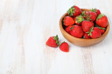 Kahverengi bir kabın içinde olgun çilek 