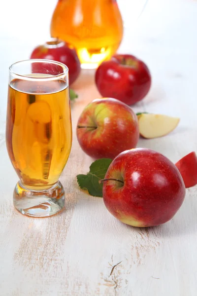 Jugo de manzana y manzanas sobre una mesa de madera —  Fotos de Stock