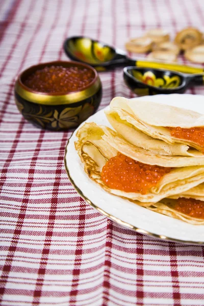 Pancakes with red caviar on a table. — Stock Photo, Image