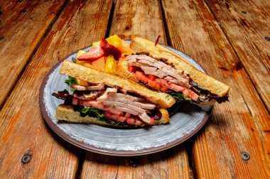 Taze ve lezzetli bir pastırmalı marul ve domatesli sandviç.