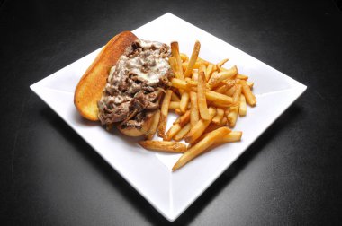 Philly peynirli biftek ve patates kızartması.