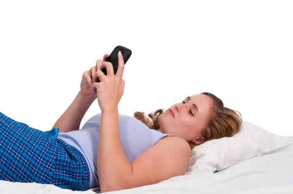 Vrouw texting in bed — Stockfoto