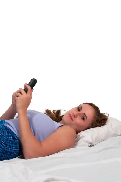 ベッドの中で女性のテキスト メッセージ — ストック写真