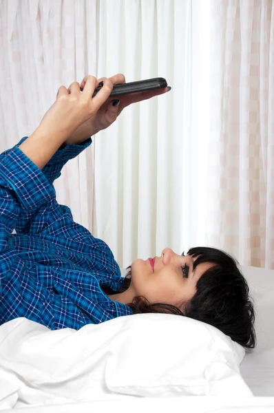 Vrouw texting in bed — Stockfoto
