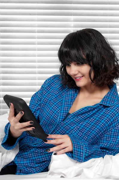 Vrouw texting in bed — Stockfoto