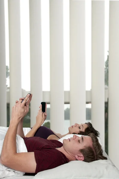 Couple texting in bed — Stock Photo, Image