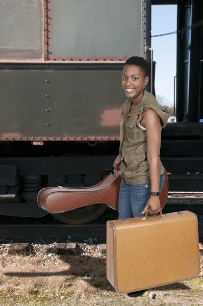 Vrouw met gitaar en koffer — Stockfoto