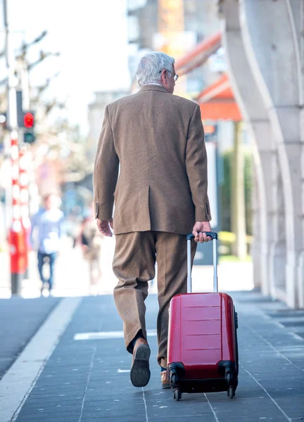 Oude Man Loopt Met Koffer Trekken Achter — Stockfoto