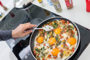 Taze yumurta ve sebzelerle kahvaltı hazırlarken.