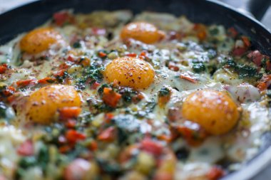 Taze yumurta ve sebzelerle kahvaltı hazırlarken.