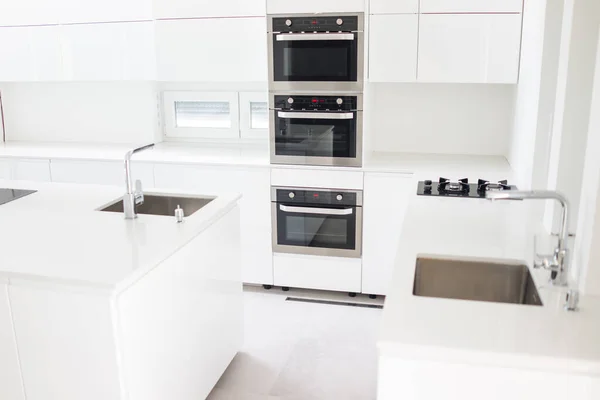 Biała, zorganizowana kuchnia z nowoczesnymi elementami w mieszkaniu — Zdjęcie stockowe