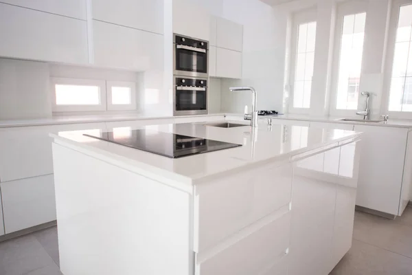Biała, zorganizowana kuchnia z nowoczesnymi elementami w mieszkaniu — Zdjęcie stockowe