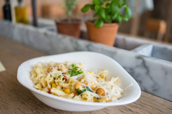 Massa com legumes verdes e molho cremoso em tigela preta no fundo de pedra cinza. — Fotografia de Stock