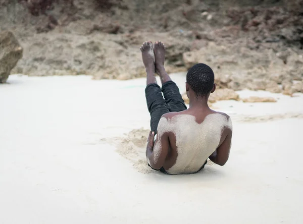 Gespierde zwarte man met training op tropisch strand — Stockfoto