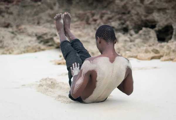 Muscular black man having workout on tropical beach