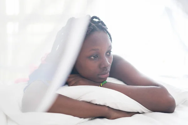 Joven hermosa chica negra despertando en la cama del dormitorio — Foto de Stock