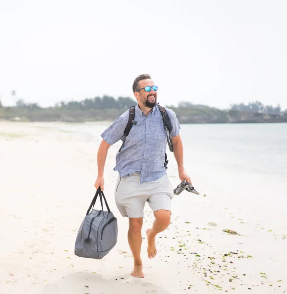 陽気な大人の男とともにバッグ楽しいです熱帯のビーチ — ストック写真