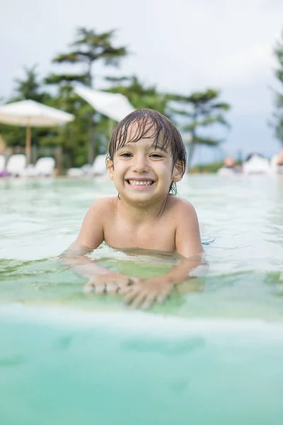 Ragazzo bambino spruzzi in piscina divertendosi attività ricreative — Foto Stock