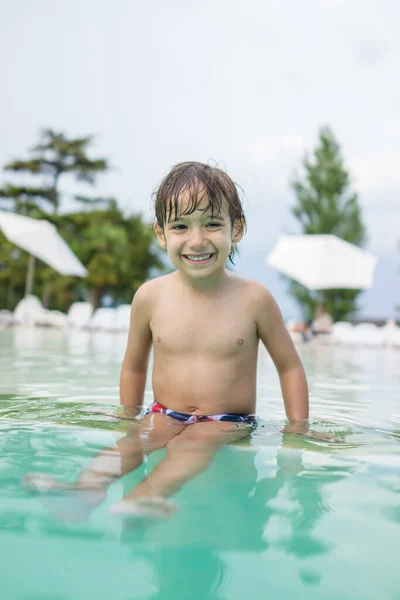 Jong jongen kind spetteren in het zwembad met plezier vrijetijdsbesteding — Stockfoto