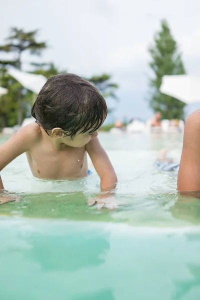 Ragazzo bambino spruzzi in piscina divertendosi attività ricreative — Foto Stock