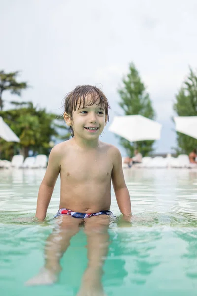 Niño pequeño niño chapoteando en la piscina divertirse actividad de ocio —  Fotos de Stock