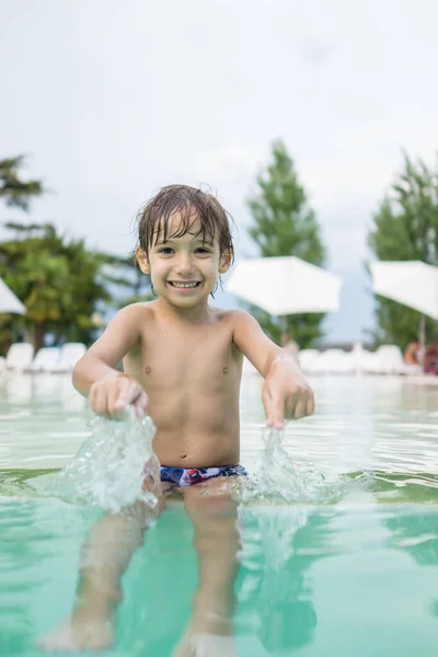 楽しいレジャー活動を持っているスイミングプールで水しぶき若い男の子子供 — ストック写真