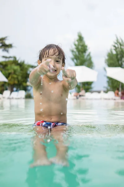 Young boy kid child splashing in swimming pool having fun leisure activity — Stock Photo, Image