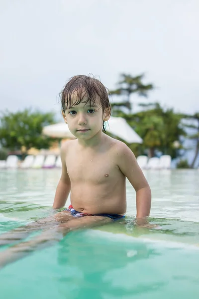 Jong jongen kind spetteren in het zwembad met plezier vrijetijdsbesteding — Stockfoto