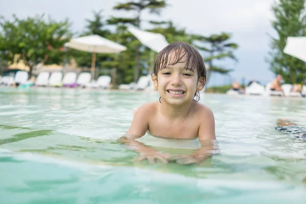 Jong jongen kind spetteren in het zwembad met plezier vrijetijdsbesteding — Stockfoto