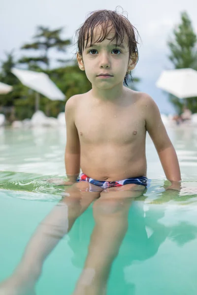 Ragazzo bambino spruzzi in piscina divertendosi attività ricreative — Foto Stock