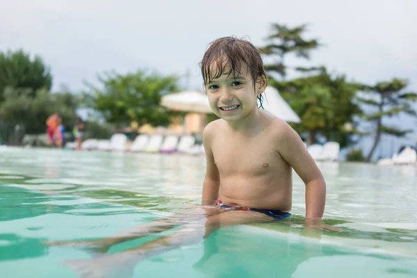 楽しいレジャー活動を持っているスイミングプールで水しぶき若い男の子子供 — ストック写真