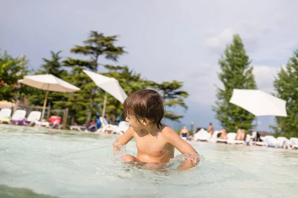 Ragazzo bambino spruzzi in piscina divertendosi attività ricreative — Foto Stock