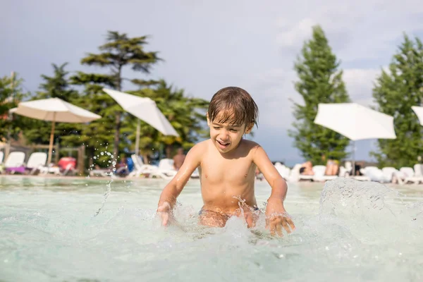 Ung pojke barn stänk i poolen ha kul fritidsaktiviteter — Stockfoto