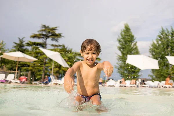 Ragazzo bambino spruzzi in piscina divertendosi attività ricreative — Foto Stock