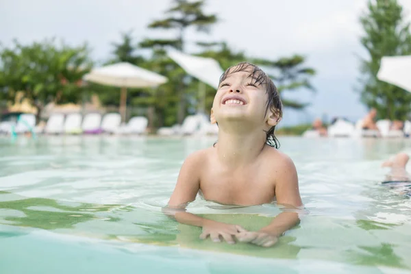 Ragazzo bambino spruzzi in piscina divertendosi attività ricreative Foto Stock