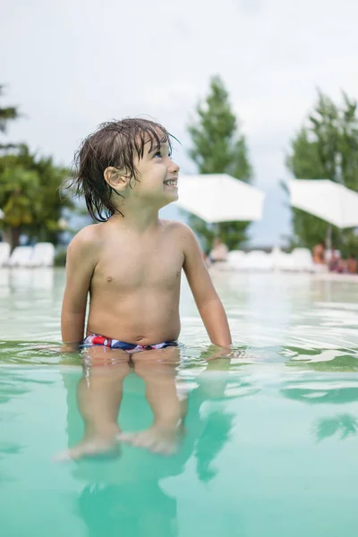 Menino menino criança salpicando na piscina tendo diversão atividade de lazer Fotos De Bancos De Imagens