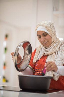 Arap güzel ev hanımı mutfakta yemek hazırlıyor.