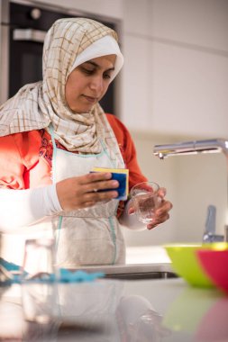 Müslüman geleneksel kadın mutfakta temizlik yapıyor.