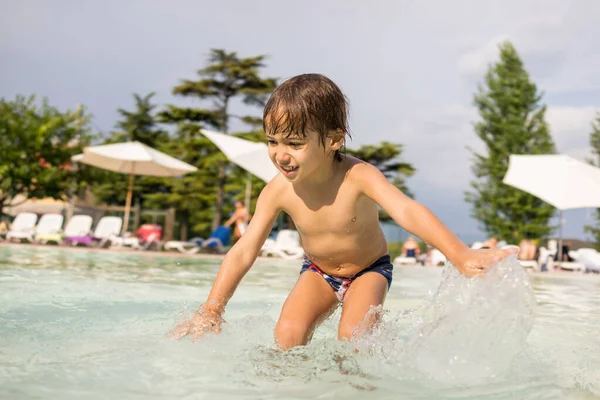 Mladý chlapec dítě stříkající v bazénu baví volnočasové aktivity — Stock fotografie