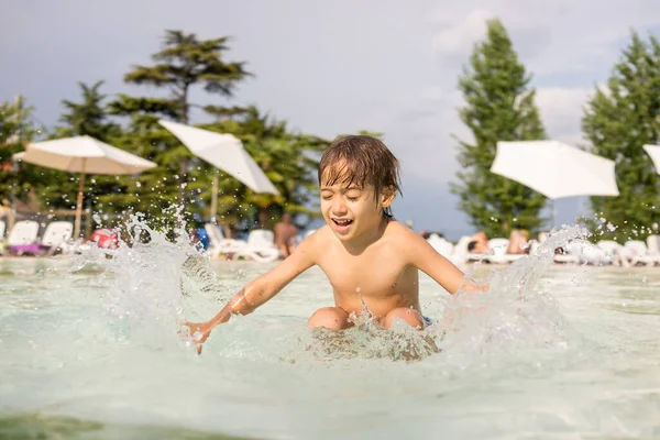 Mladý chlapec dítě stříkající v bazénu baví volnočasové aktivity — Stock fotografie