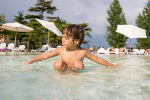 Young boy kid child splashing in swimming pool having fun leisure activity — Stock Photo, Image