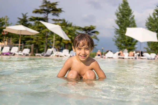 Jeune garçon enfant éclaboussures dans la piscine avoir plaisir loisirs — Photo