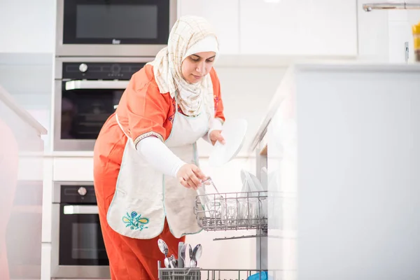 Muslimská tradiční žena úklid v kuchyni — Stock fotografie