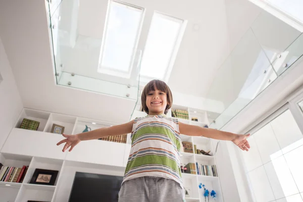 Gelukkig kind thuis met handen omhoog — Stockfoto