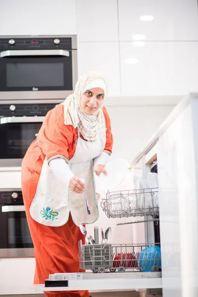 Muslimská tradiční žena úklid v kuchyni — Stock fotografie