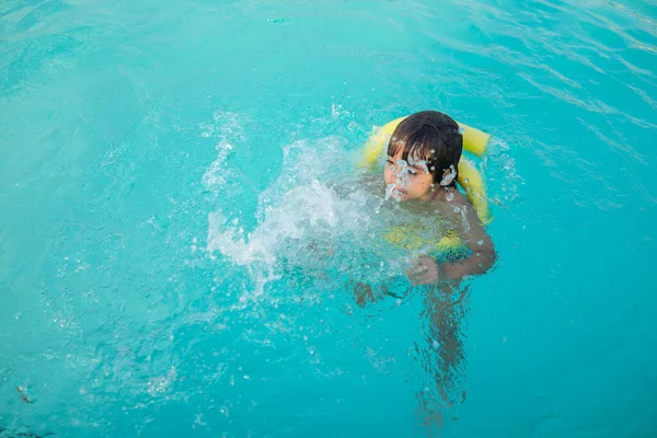 어린 소년이 수영장에서 재미있는 여가 활동을 하는 모습 — 스톡 사진