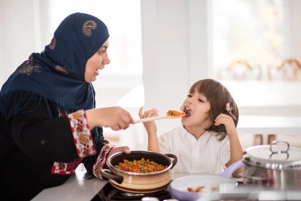 Musulmana tradicional mujer con agradable niño en casa — Foto de Stock