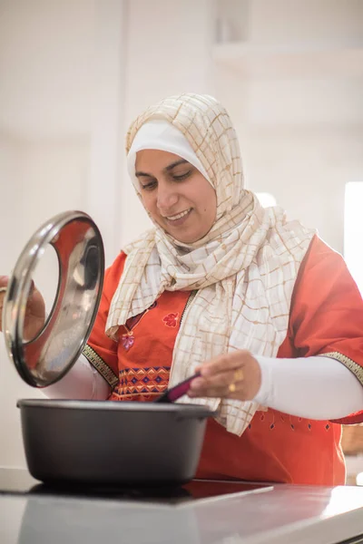 Αραβική όμορφη νοικοκυρά κάνει ένα γεύμα στην κουζίνα — Φωτογραφία Αρχείου