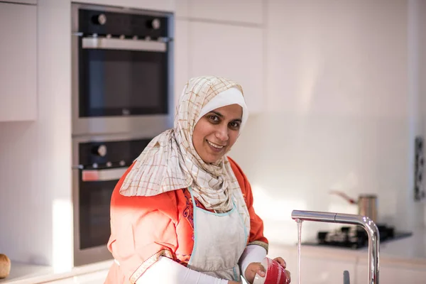 Mulher tradicional muçulmana limpeza na cozinha — Fotografia de Stock